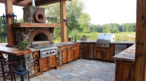 Outdoor kitchen with built-in grill and fire pit by Cole Landscaping